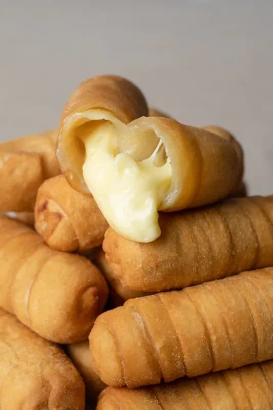 Tequeño frito partido con el queso estirando